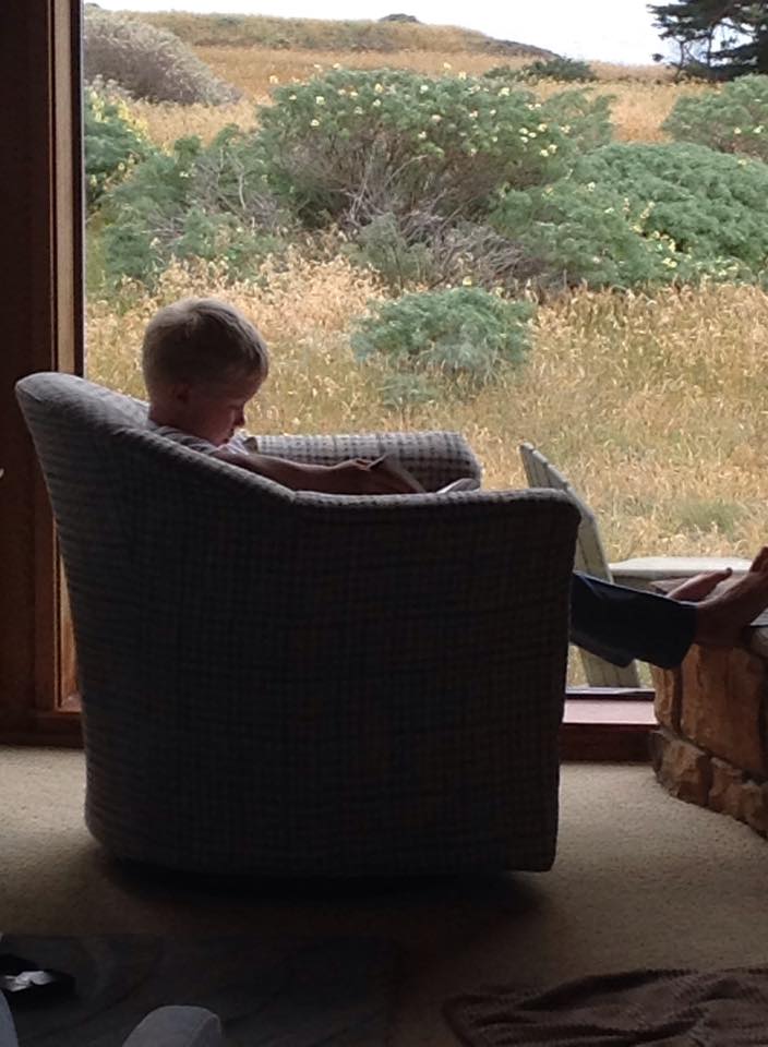 Child reading while vacationing at Sea Ranch Abalone Bay