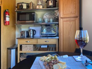 Kitchen appliances in background, bistro table with wine and cheese