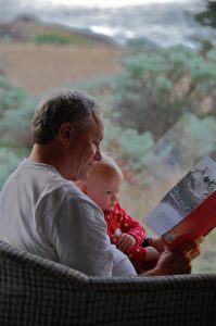 Grandfather reading story to grand daughter at sea ranch abalone bay