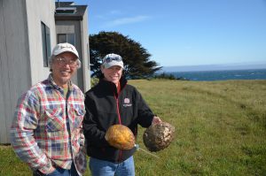 two men next to vacation rental Sea Ranch Abalone Bay, owner holds to large red abalone