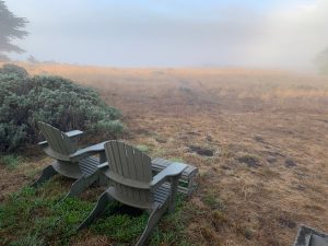 Chairs in front of Sea Ranch as fog covers the horizon