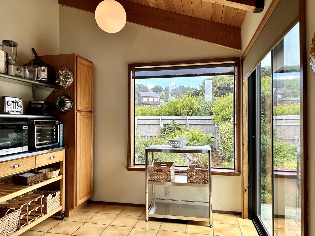 Small kitchen storage for Sea Ranch Abalone Bay vacation rental includes open shelves of stainless steel and stand alone stainless shelving