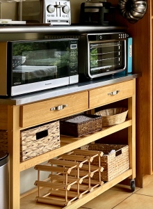Baskets in open shelves and a wooden wine rack help with storage